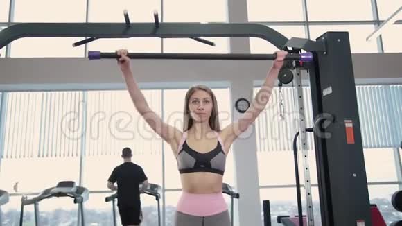 漂亮的运动年轻女孩在健身房里用体操棒练习视频的预览图
