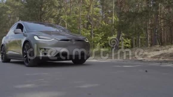 现代灰色电动车在森林附近的道路上骑行视频的预览图