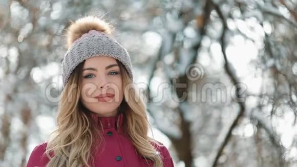 一位金发碧眼的年轻女子的画像戴着冬日户外运动帽微笑着快乐地看着镜头视频的预览图