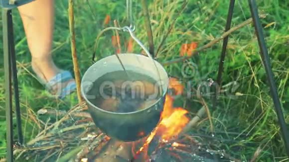 一壶煮土豆挂在燃烧的火上视频的预览图