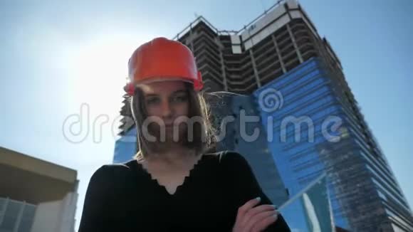 年轻强壮的女建筑工人带着褶边站着夏天白天交叉双臂建筑概念城市概念视频的预览图