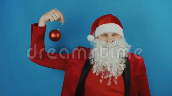 新年像圣诞老人一样带着蓝色背景的圣诞红球玩具视频的预览图