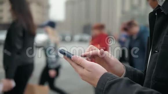 男人在户外使用手机关门男人拿着手机走在街上人们和汽车背景视频的预览图