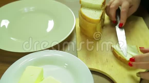女人在面包上涂黄油做罐头视频的预览图