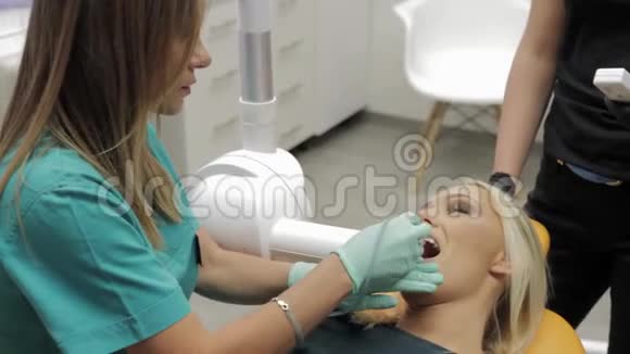 一位牙医的女性照片为一位病人做了一张X光照片上面写着她的病人戴着牙套暗示她要取哪种牙齿颜色视频的预览图
