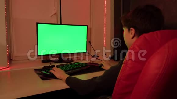 一个少年坐在一张红色的椅子前的绿色电脑屏幕视频的预览图