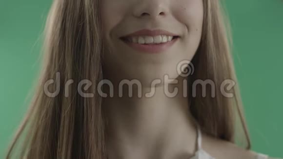 性感的年轻女人咬着嘴唇贴在绿色的背景上视频的预览图