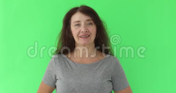 50多岁的成熟女人对着镜头微笑的肖像视频的预览图