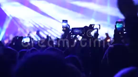 粉丝在节日里拍摄音乐会的照片和视频视频的预览图