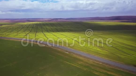 从高处看乡村风景绿野和如画的云彩在天空和道路之间的两片田野视频的预览图