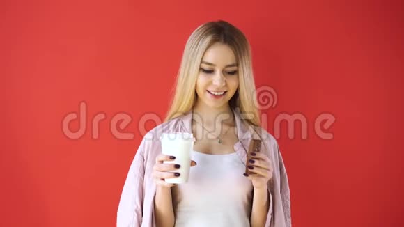 红色背景的女孩咬巧克力喝咖啡视频的预览图