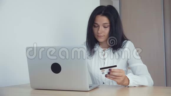 商务女性用信用卡和笔记本电脑在线购物视频的预览图