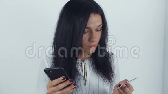 年轻女子用信用卡和智能手机上网购物视频的预览图