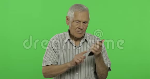 老人用智能手机说话性感钥匙背景上英俊的老人视频的预览图