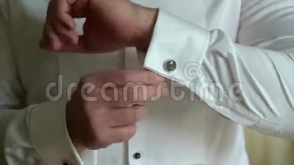 穿着袖扣的商人穿着白色衬衫的人把袖扣放好并调整袖扣新郎早上准备好视频的预览图