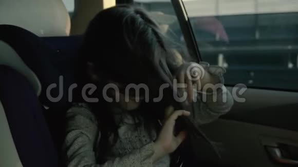 在婴儿座椅上玩头发的快乐活泼的小女孩视频的预览图