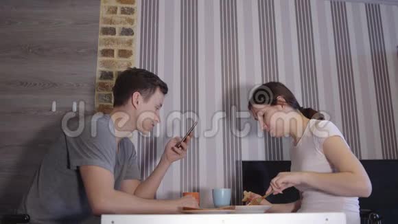 有电话的年轻人和吃饭的女人视频的预览图