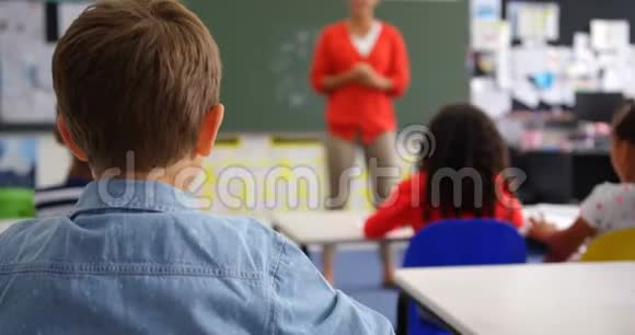 男生在教室里举手的后视图视频的预览图