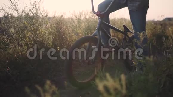 骑自行车的人在日落时骑在他的BMX户外慢动作特写视频的预览图