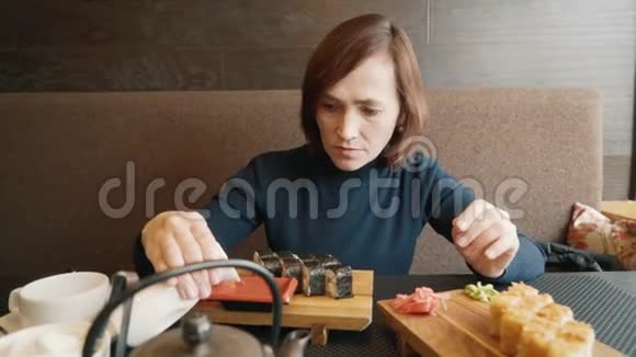 女人在吃寿司一个女人正在倒酱油视频的预览图