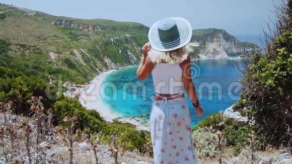 美丽的金发女人戴着太阳帽在希腊的凯法洛尼亚岛享受海滩度假快乐生活夏日视频的预览图