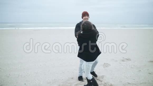 爸爸和女儿牵着手在海滩上荡秋千视频的预览图