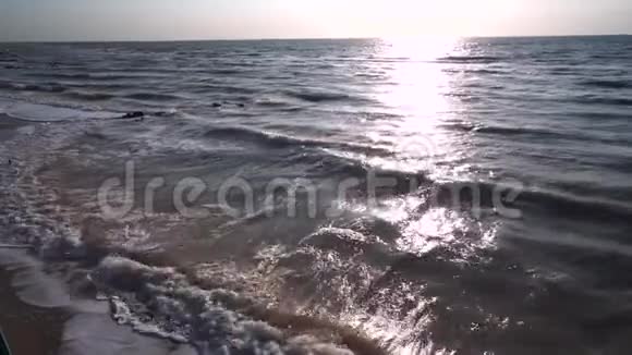灰色的大海在夏天在刮风的天气力浪泡沫形成在海岸和冲浪太阳路径视频的预览图
