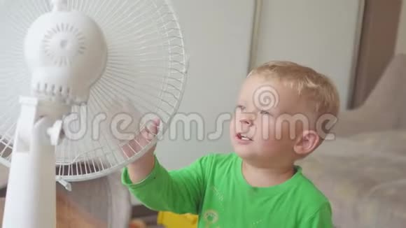 童年家的概念可爱的小男孩与大冷却风扇视频的预览图