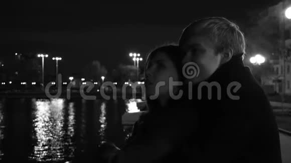 年轻的夫妻激情拥抱在城市街道的夜晚一对年轻夫妇在城市公园拥抱和亲吻视频的预览图
