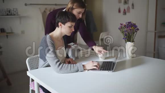 女学生在笔记本电脑上搜索互联网两个女人在看新闻视频的预览图