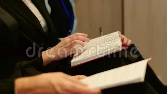 记者在新闻发布会上做笔记的笔记本和录音双手特写侧视视频的预览图