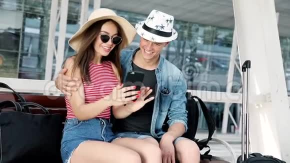 旅行一对夫妇用电话坐在机场航站楼附近视频的预览图