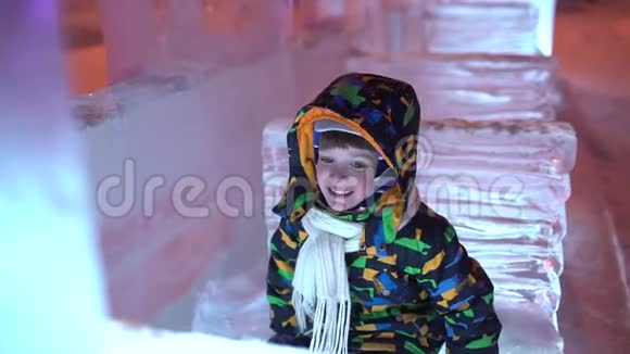 可爱的小男孩在圣诞城户外玩得很开心男孩在圣诞街背景上玩得很开心开心有趣可爱视频的预览图