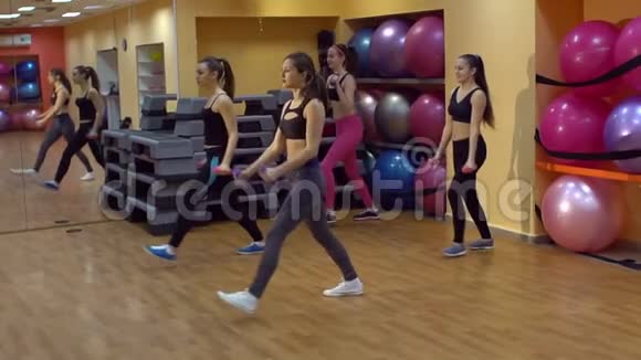 一群快乐的女孩在健身房训练哑铃视频的预览图