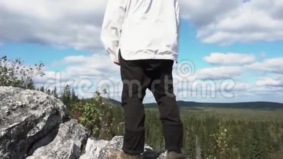 游客独自站在山林景观旁在攀岩的后景在阳光下眺望地平线视频的预览图