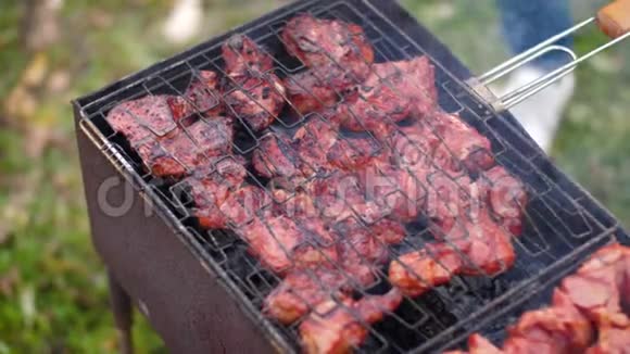用烤肉把烤架翻起来慢动作60fps露天烧烤多汁的肉在烤架上热煤和烟雾视频的预览图