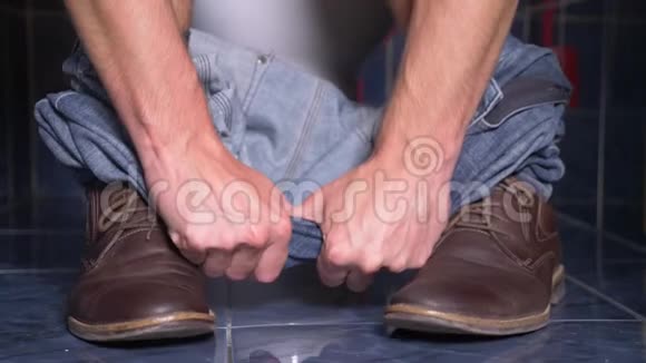 坐在马桶里肚子痛的人的脚4k特写穿着裤子和鞋子的男人视频的预览图