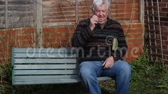 老人坐在长凳上看书视频的预览图