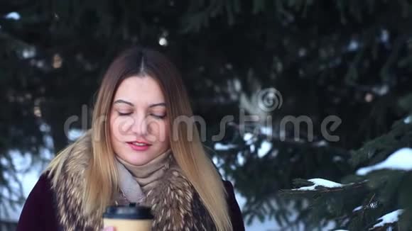 冬天美丽的少女在公园里喝咖啡视频的预览图