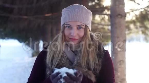 一个美丽的女孩享受大自然用手吹雪视频的预览图