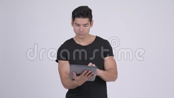快乐年轻英俊的多民族男人在使用数码平板电脑时思考视频的预览图