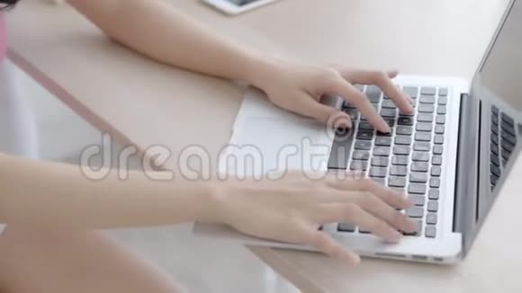 特写自由职业妇女微笑着在办公桌办公室的笔记本电脑上工作和打字配有专业人员视频的预览图
