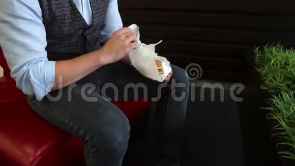 一个男人坐在咖啡馆里打开三明治视频的预览图