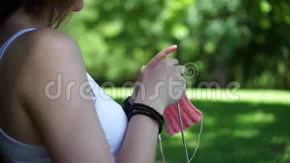 小女孩在公园的树下编织视频的预览图