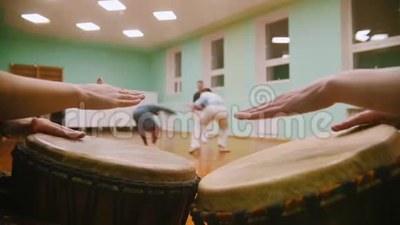 在背景上演奏乐器jembe或atabaque男性拳击手用舞蹈元素表演武术技巧视频的预览图