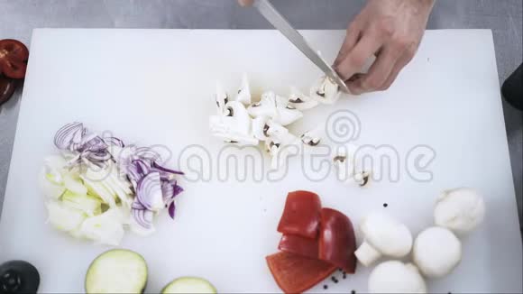 厨师用手在切割板上切蘑菇的俯视图视频的预览图