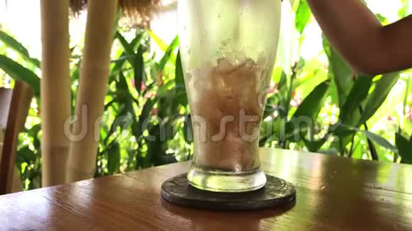 在热带背景下在巴厘岛倒入带有冰的软饮料可乐视频的预览图