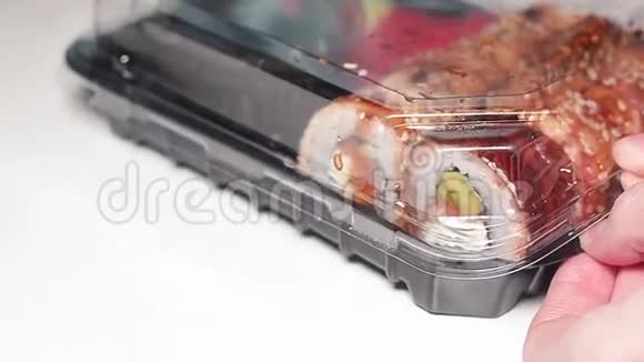 女人打开一个塑料容器里面有新鲜的日本寿司视频的预览图