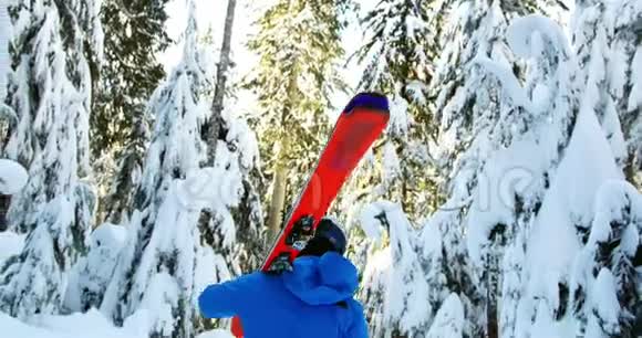 用滑雪板和滑雪杆行走的人的后视图视频的预览图