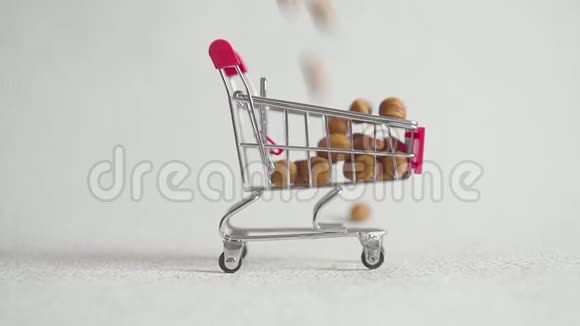 超市里的购物车里装满了榛子坚果榛子掉进超市手推车里视频的预览图